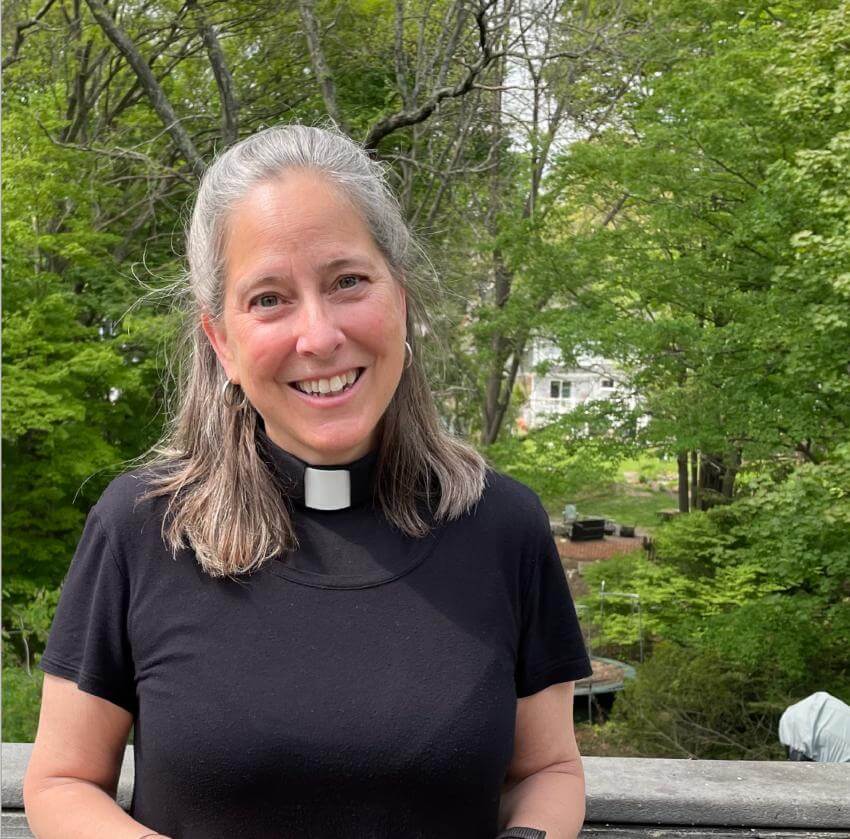 Gray-hair woman in minister top standing in garden